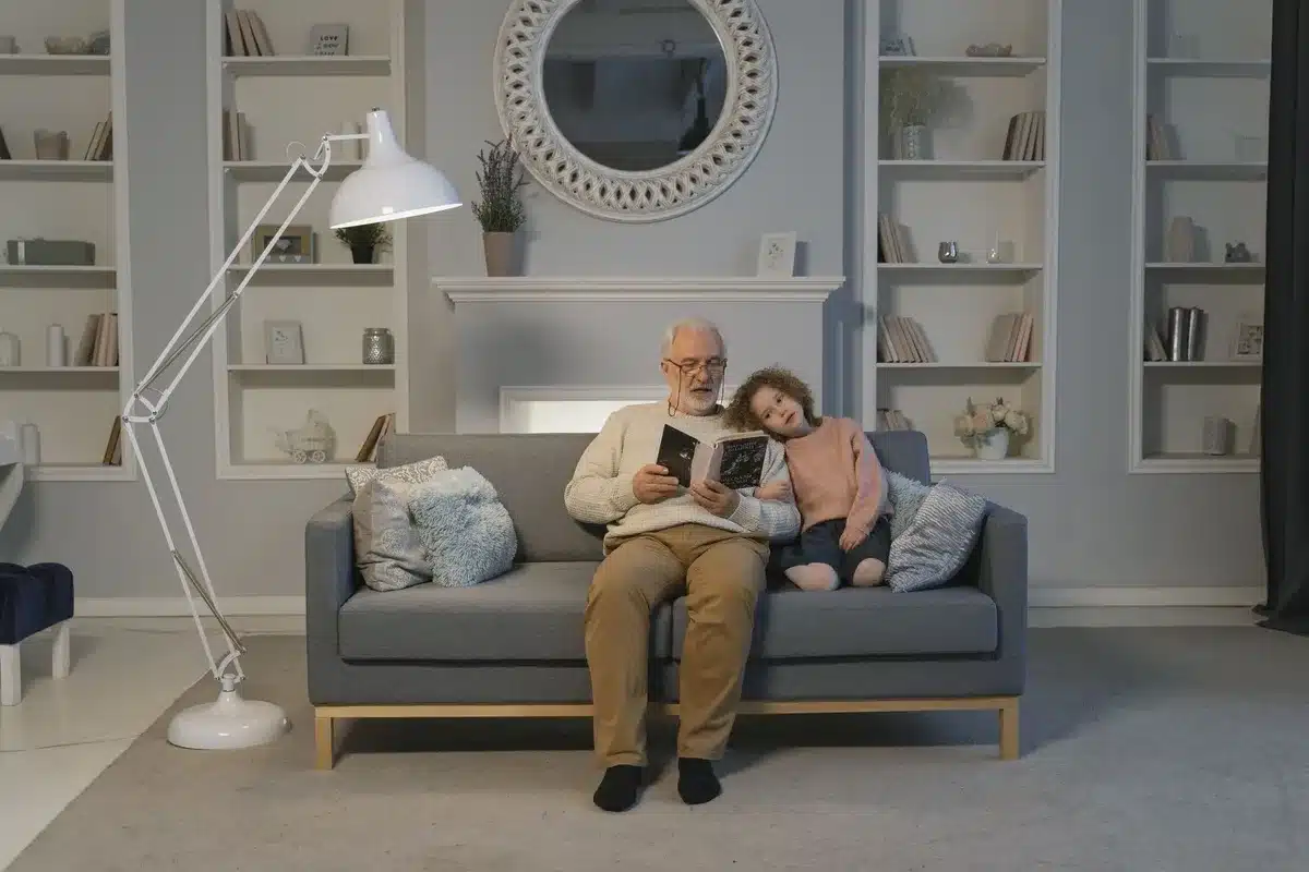 Großelternteil und Kind sitzen gemeinsam beim Lesen