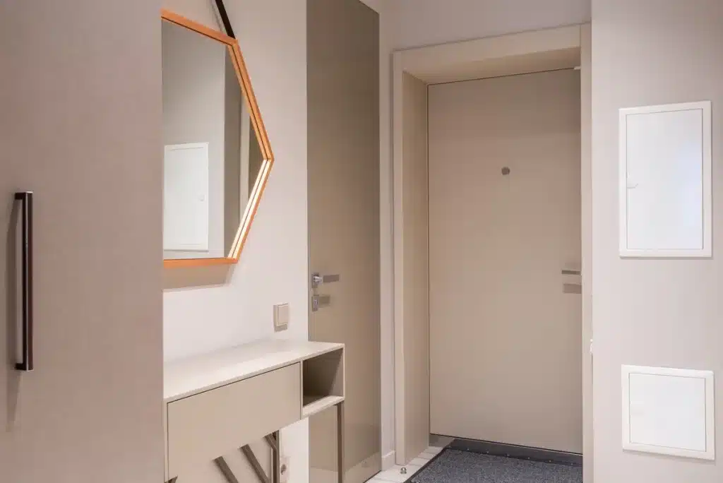 Strak ingerichte woonkamer in beige- en grijstinten met minimalistische meubels en metallic accenten