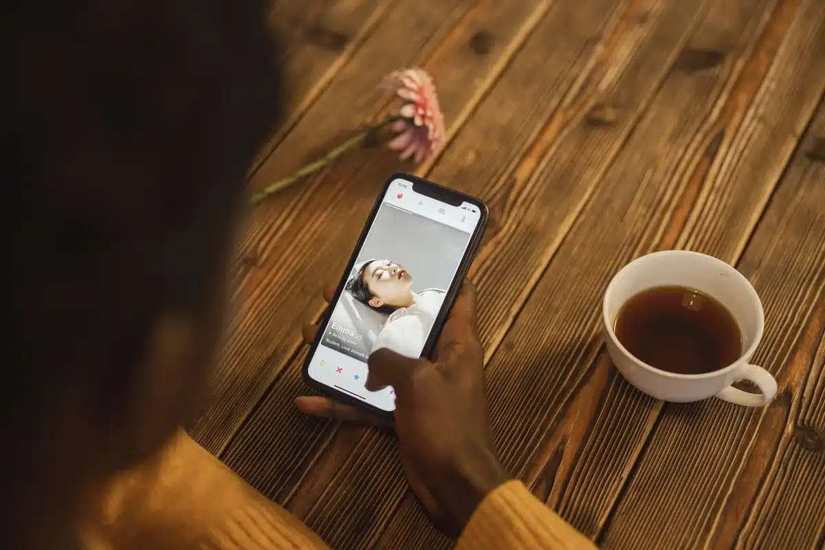 Person hält Smartphone und nutzt Dating-App zur Kontaktsuche