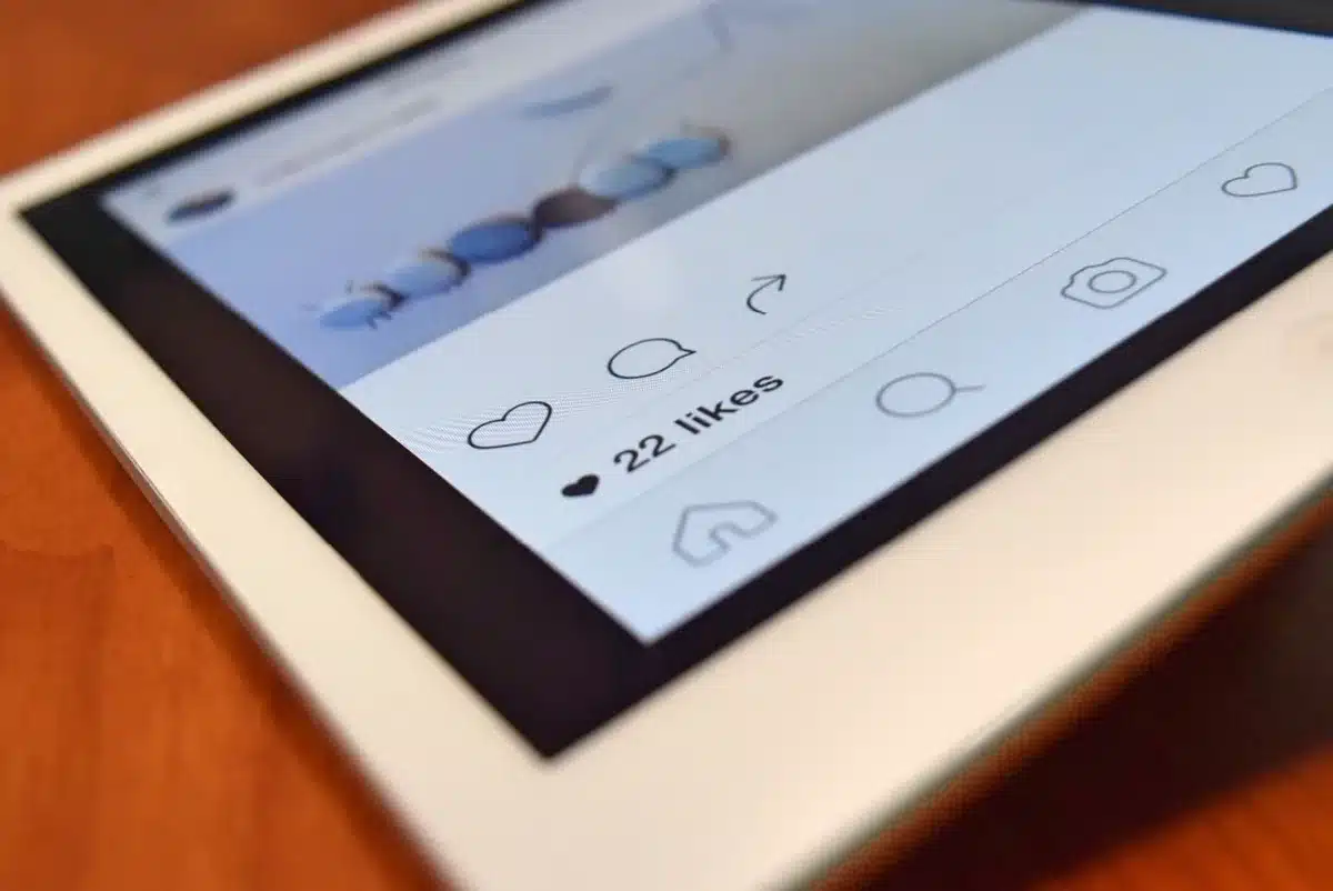 Persoon die op een smartphone door sociale media schuift met likes en reacties zichtbaar