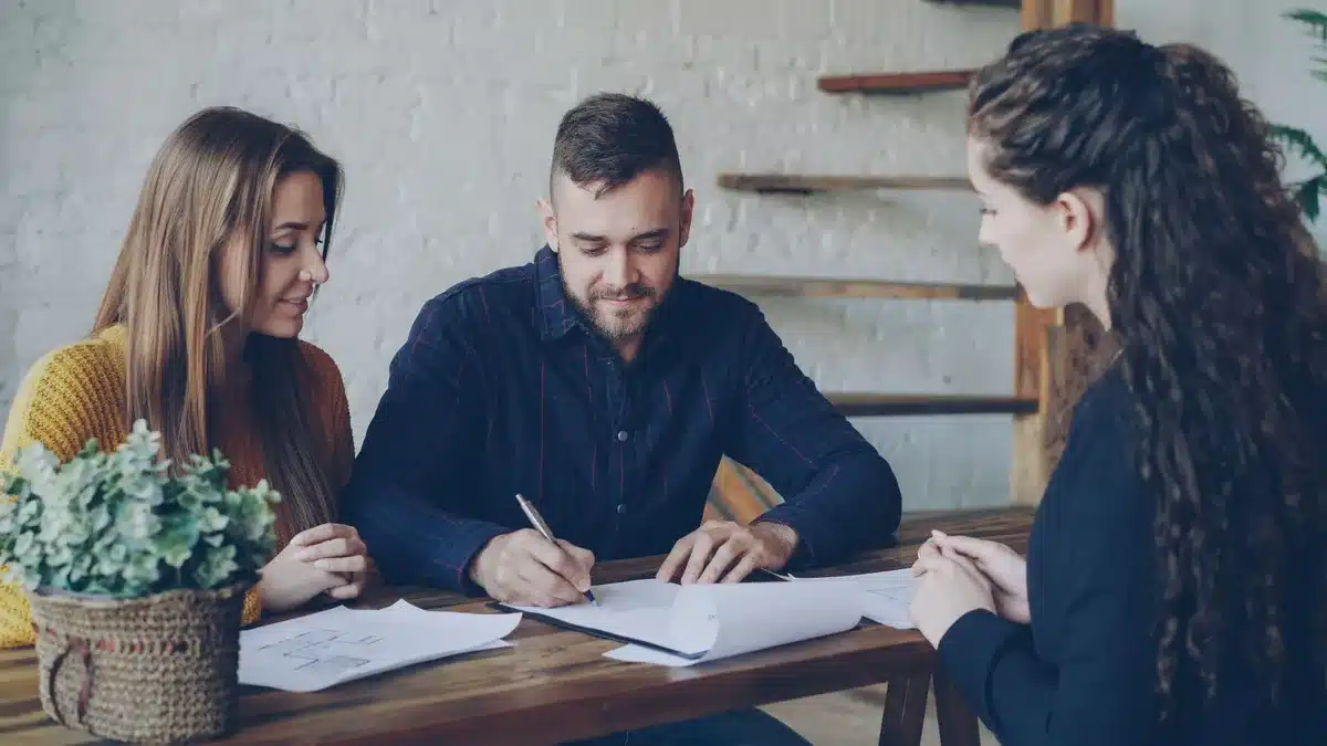 Paar bespricht Immobiliendokumente und Verträge am Schreibtisch