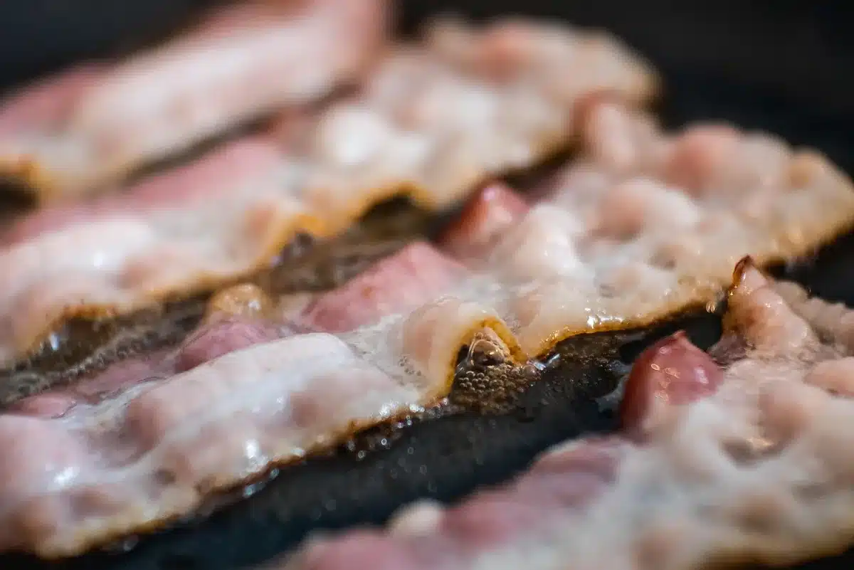 Nahaufnahme: Baconscheiben werden vorsichtig zu einer Rolle geformt