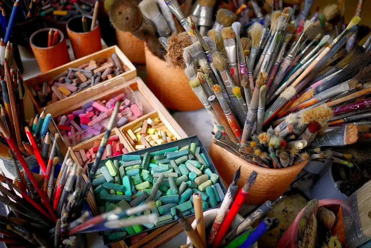 Atelier mit Farbpalette und Porträtskizzen, Hinweis auf Saleschs künstlerische Arbeit