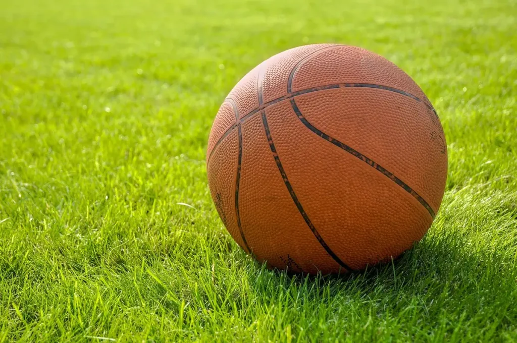Anonieme silhouet naast strategisch geplaatste sportballen op een studio-podium