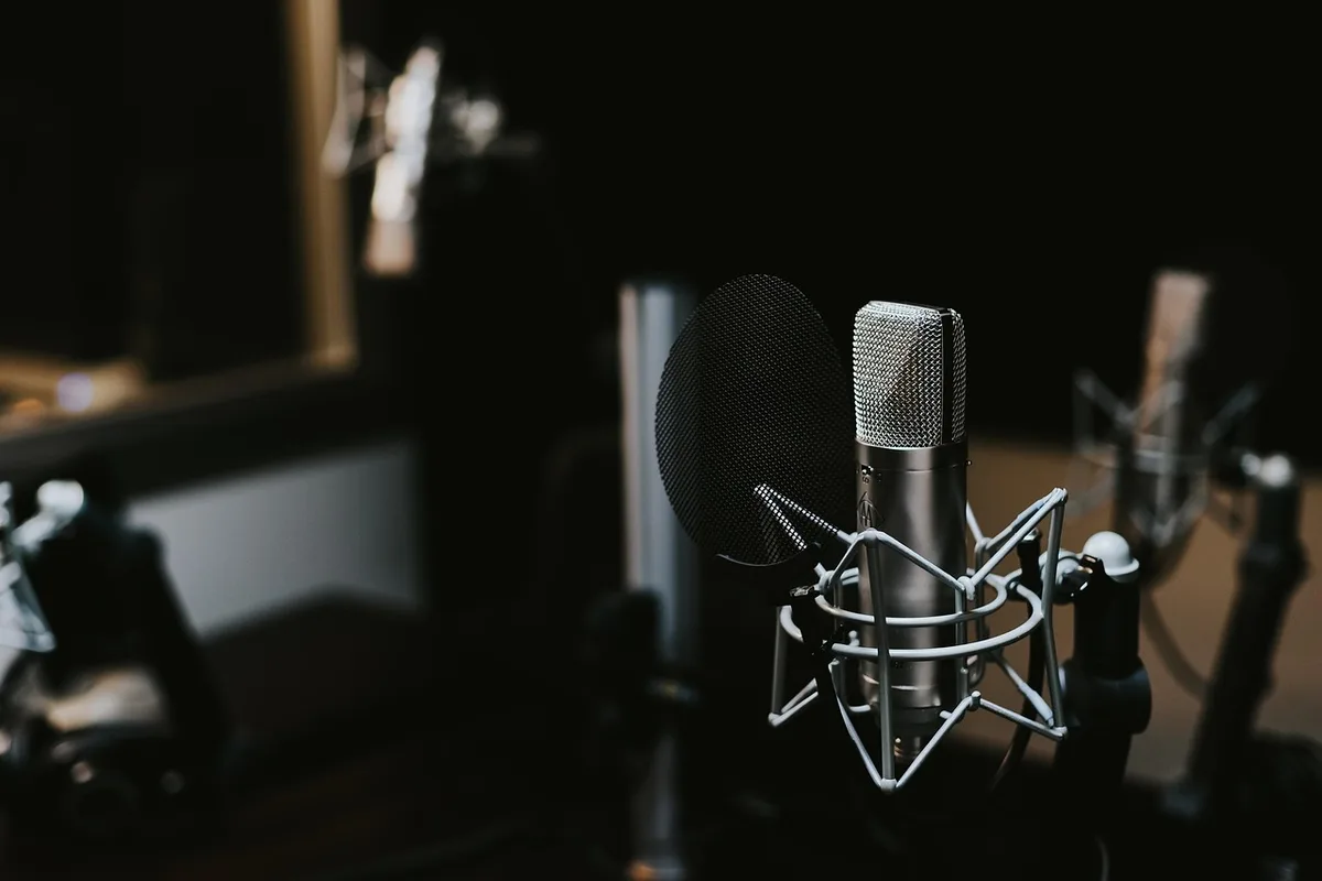 Jonge muzikant in opnamestudio met moderne audio-apparatuur en creatieve setup