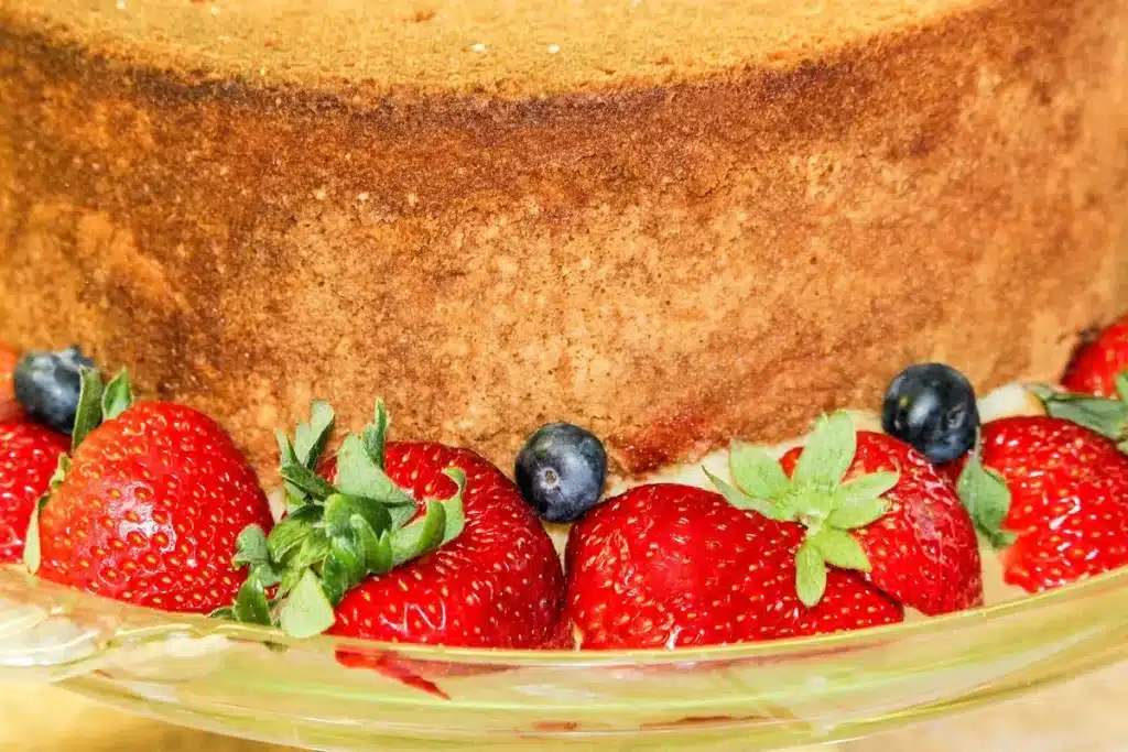 Junge Ehrenamtliche servieren Erdbeerkuchen an einem Spendencafé in historischer Umgebung