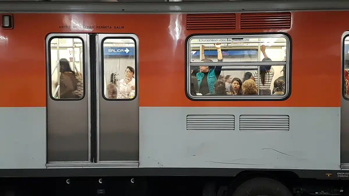 Reiziger met koptelefoon kijkt op telefoon in trein