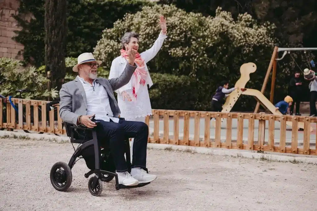 Anonieme oudere met rollator lacht op een stadsstoep, rugaanzicht