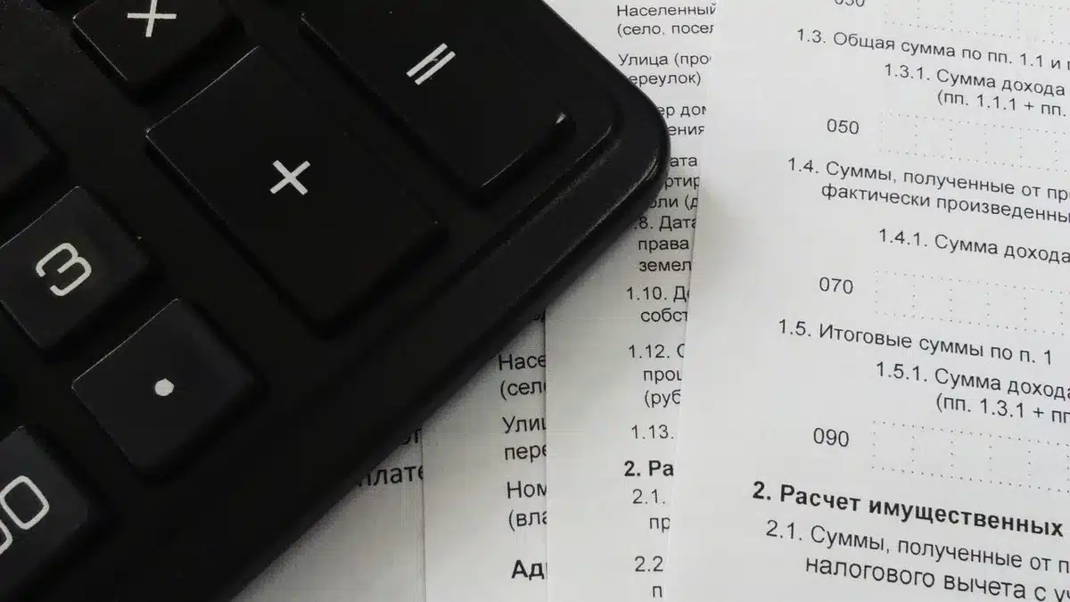 Hände über Formularen und Dokumenten auf Schreibtisch