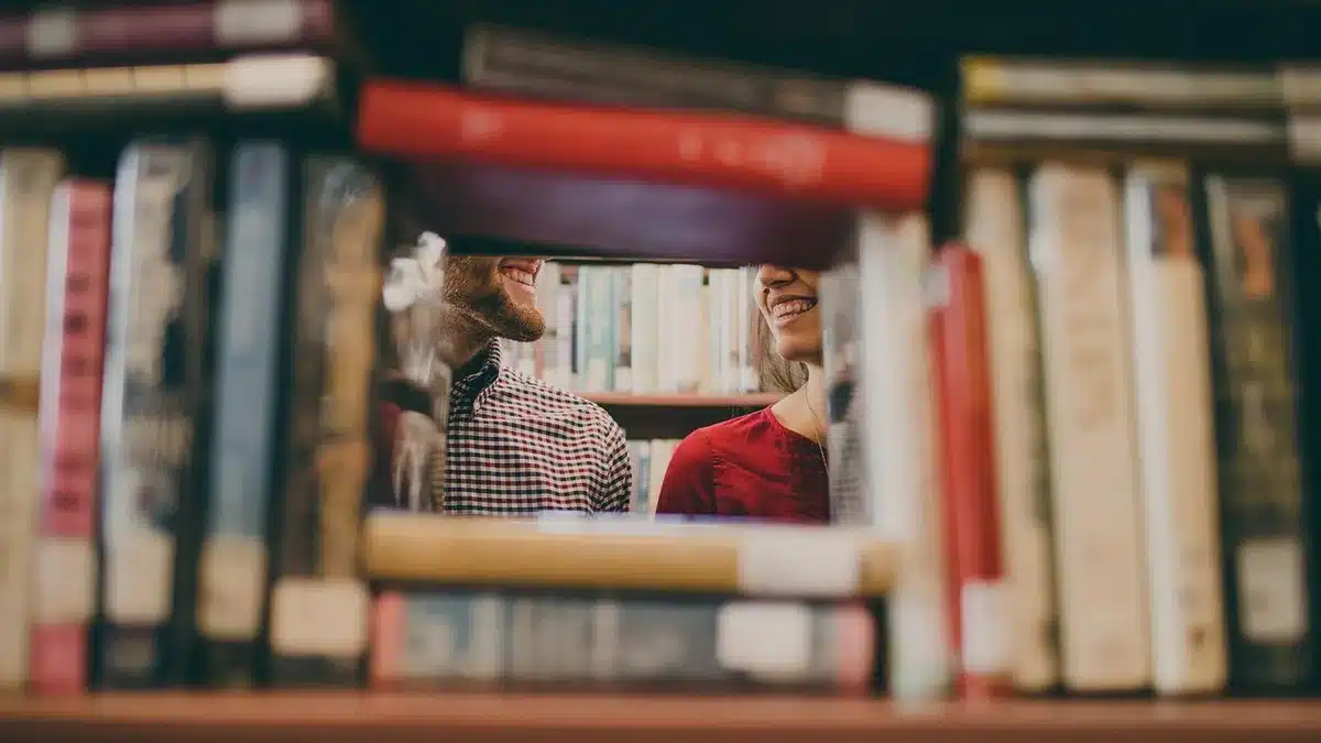 Junge Frau mit Büchern in einer Bibliothek als Symbol für Ranias Ausbildung