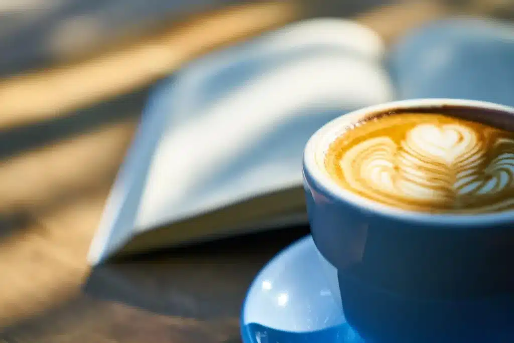 Zwei Paare Hände auf einem Cafétisch, anonym, symbolisch für Nähe und Beziehung