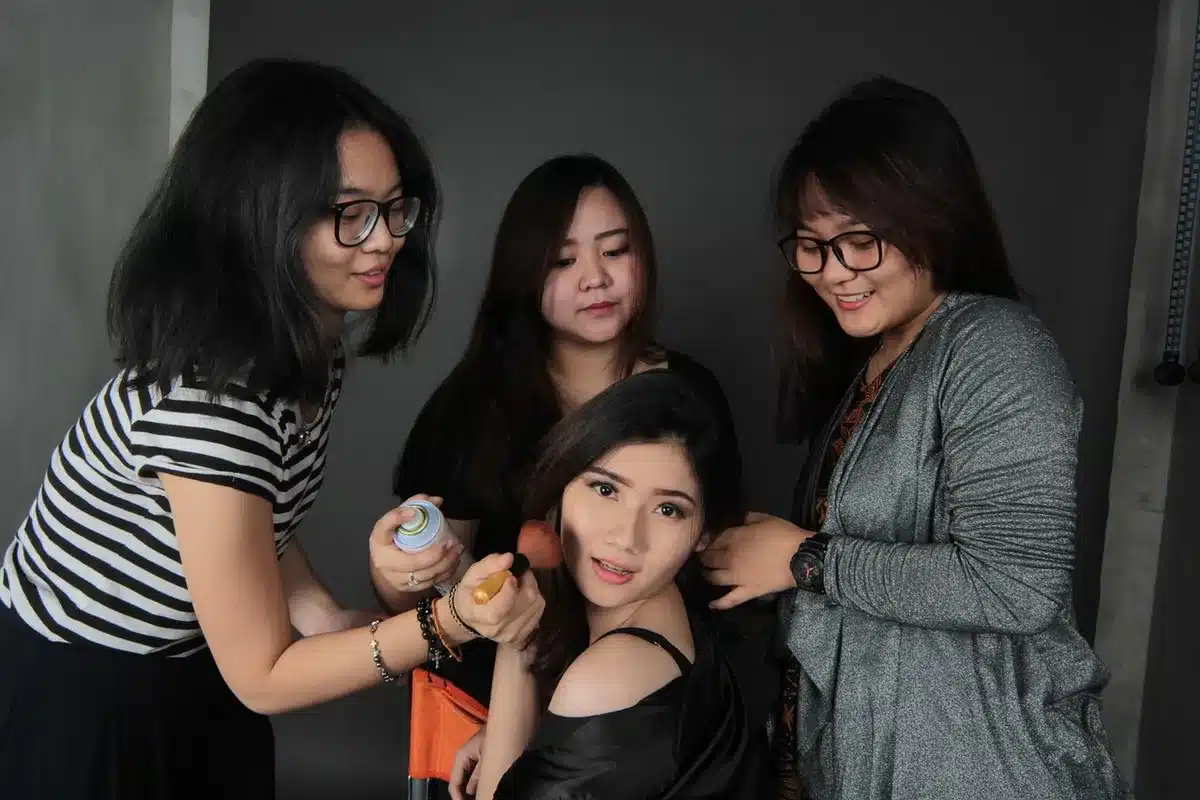 Backstagebeeld met modellen die hun make-up en telefoons gebruiken