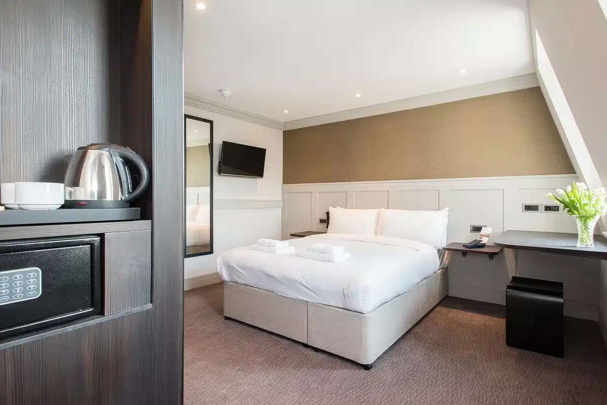 Leerer Hotelraum mit Koffer und Strandutensilien, Symbol für weggefallene Alltagsstrukturen